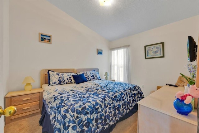 carpeted bedroom with vaulted ceiling and a textured ceiling