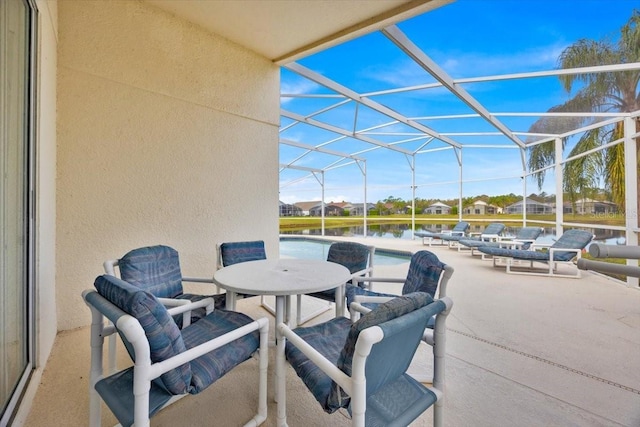 view of patio / terrace featuring a lanai, a water view, and an outdoor pool