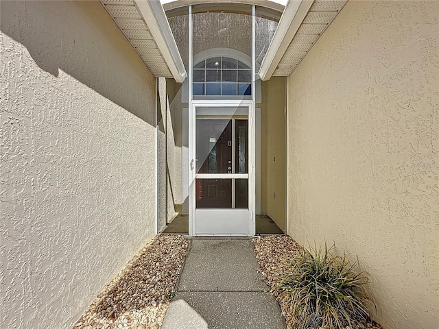 entrance to property featuring stucco siding