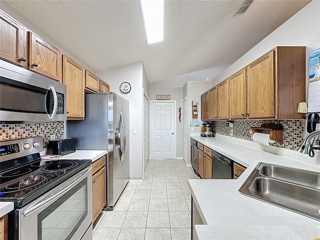 kitchen featuring visible vents, a sink, stainless steel appliances, light countertops, and light tile patterned floors