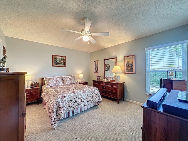 bedroom featuring light carpet, a textured ceiling, a ceiling fan, and baseboards