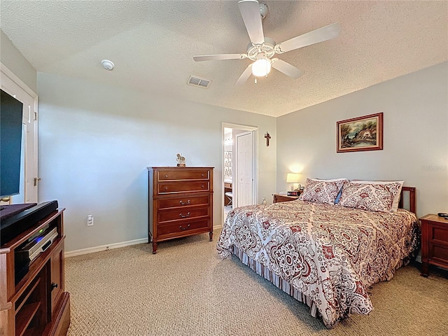 bedroom featuring baseboards, visible vents, ceiling fan, a textured ceiling, and light carpet