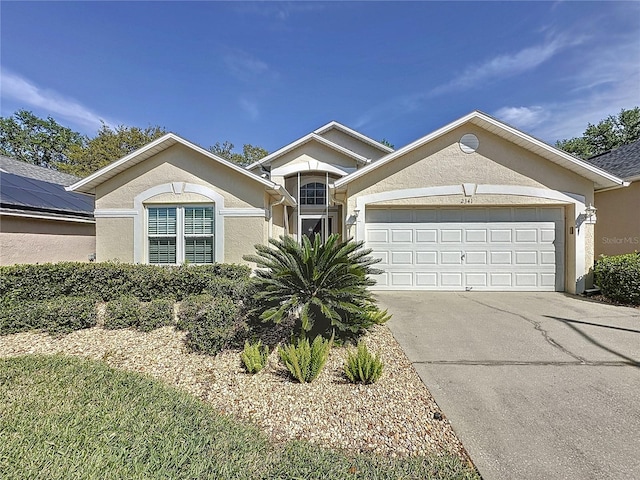 single story home with stucco siding, driveway, and a garage