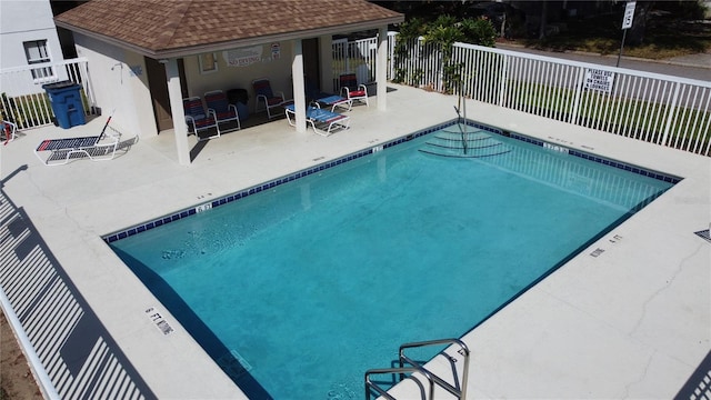 pool with a patio and fence