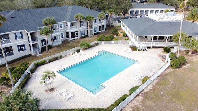 community pool with a patio and fence