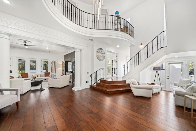 entrance foyer featuring stairway, dark wood-style floors, ornate columns, and a healthy amount of sunlight