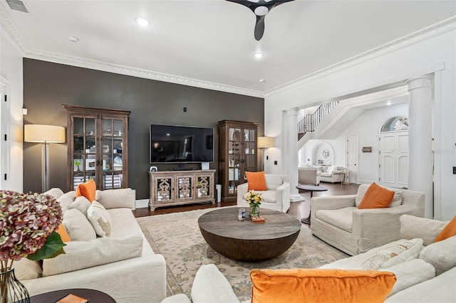 living room with decorative columns, wood finished floors, visible vents, and ornamental molding