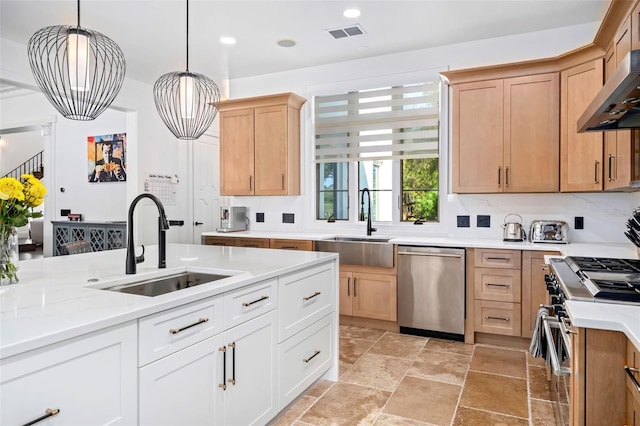 kitchen featuring visible vents, ventilation hood, stainless steel appliances, and a sink