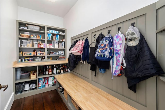 mudroom with dark wood finished floors and baseboards