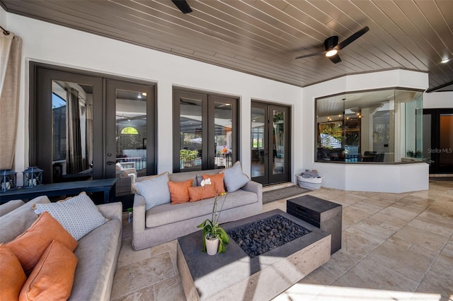 view of patio with an outdoor living space with a fire pit, french doors, and a ceiling fan