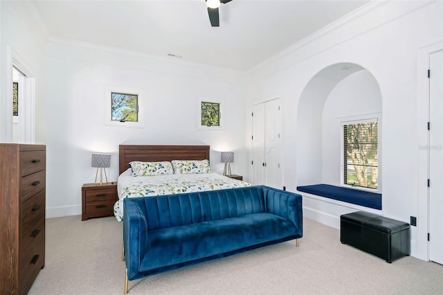 bedroom with baseboards, light carpet, a ceiling fan, and crown molding