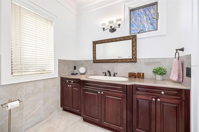 bathroom with tile walls, ornamental molding, and vanity