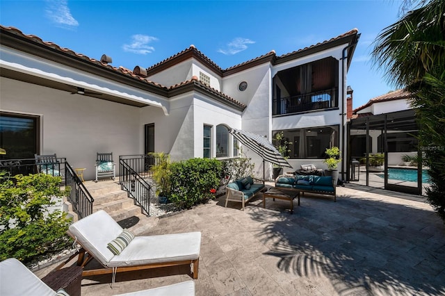 back of property featuring stucco siding, an outdoor living space, a patio area, an outdoor pool, and a tiled roof