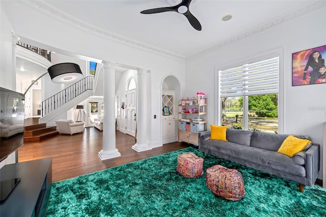 interior space featuring a ceiling fan, wood-type flooring, ornate columns, and ornamental molding