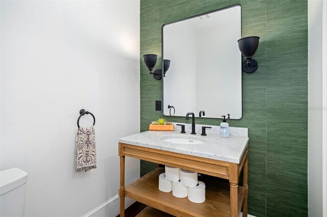 bathroom featuring baseboards, toilet, and vanity