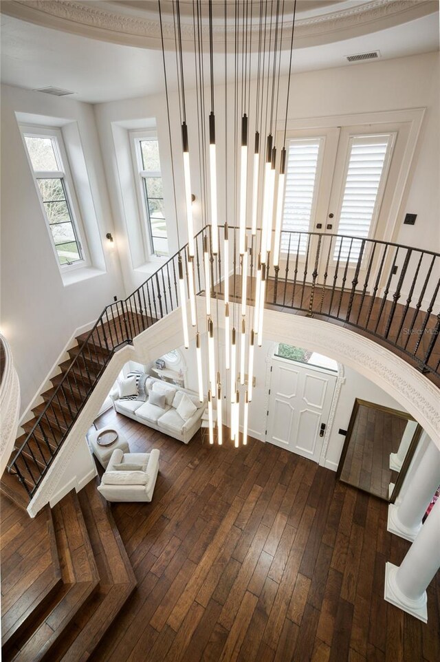 stairs with hardwood / wood-style floors and visible vents