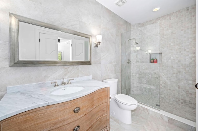 full bathroom featuring vanity, visible vents, walk in shower, tile walls, and toilet