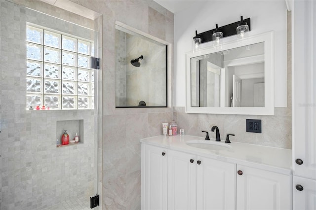 full bathroom featuring vanity, a shower stall, tile walls, and tasteful backsplash