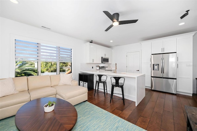 living room with a ceiling fan, recessed lighting, dark wood-style floors, and visible vents