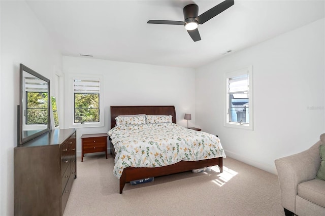 bedroom with visible vents, multiple windows, and light colored carpet