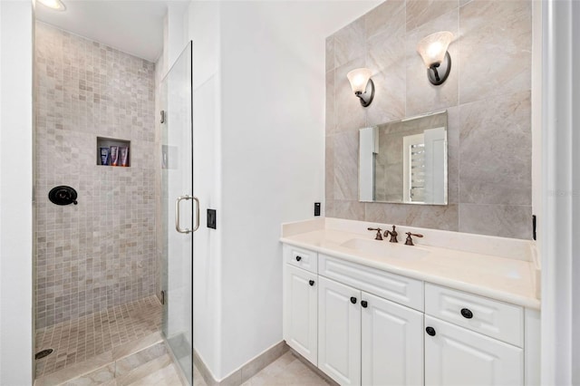 bathroom with a stall shower, vanity, and baseboards