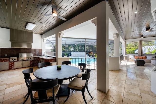 dining room featuring stone tile flooring, wooden ceiling, a ceiling fan, and a sunroom