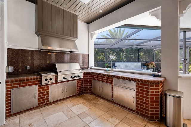 view of patio with a sink, glass enclosure, area for grilling, and exterior kitchen