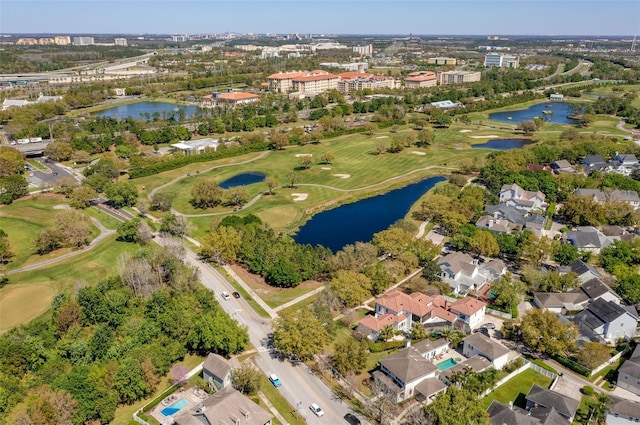 drone / aerial view with view of golf course and a water view