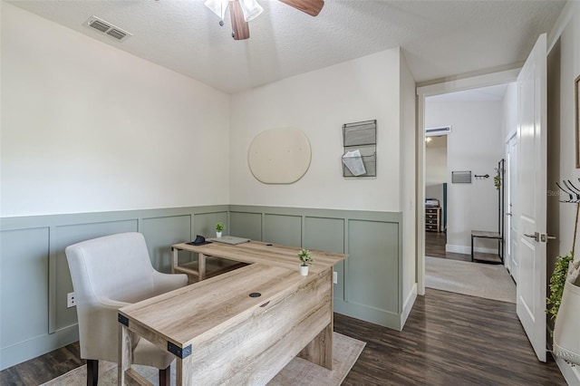 dining room featuring visible vents, a textured ceiling, dark wood-style flooring, and a ceiling fan