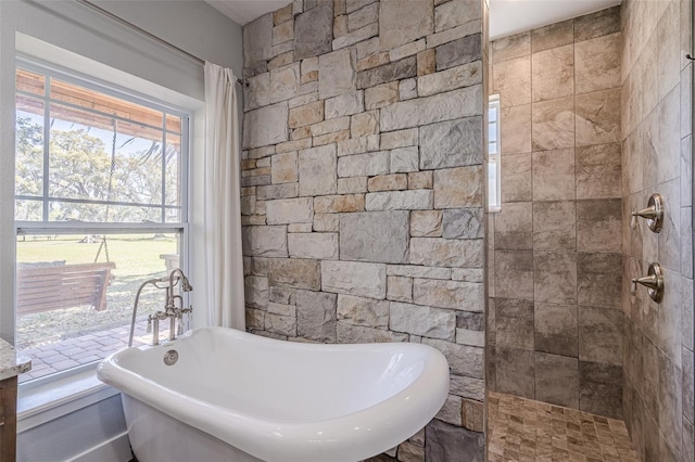 bathroom featuring tiled shower and a freestanding bath