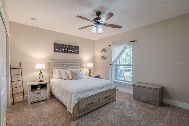 carpeted bedroom with baseboards, a textured ceiling, and a ceiling fan