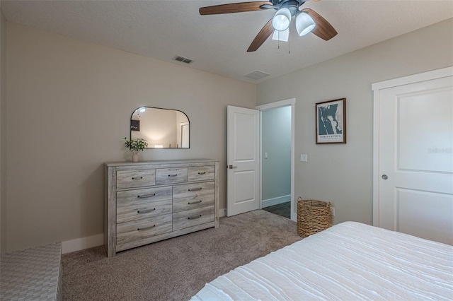 bedroom with visible vents, ceiling fan, baseboards, carpet, and a textured ceiling