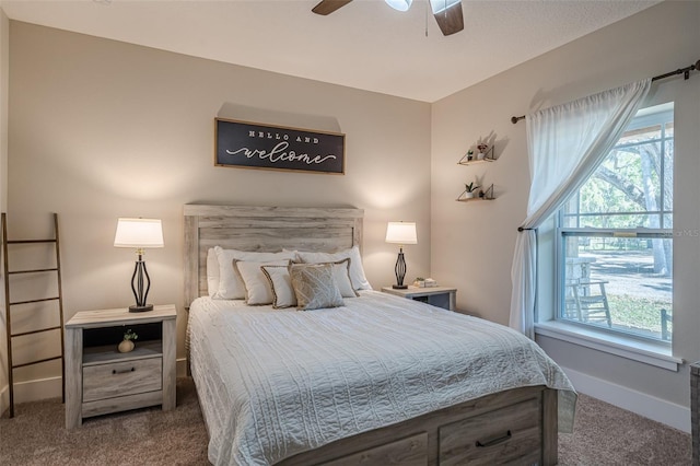 carpeted bedroom featuring multiple windows, baseboards, and ceiling fan