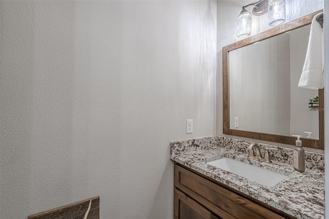 bathroom with vanity and a textured wall