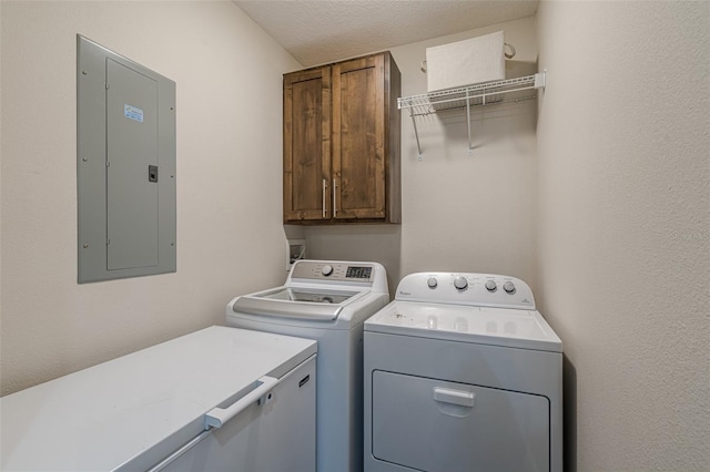 clothes washing area with washer and dryer, electric panel, cabinet space, and a textured ceiling