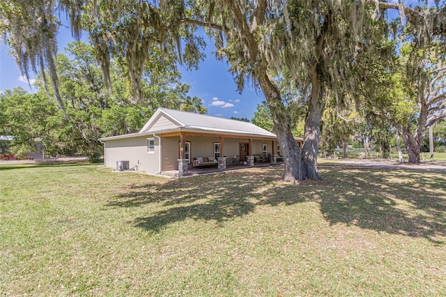 back of property with a lawn and a patio area