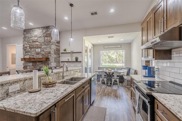 kitchen with visible vents, backsplash, appliances with stainless steel finishes, wood finished floors, and a sink