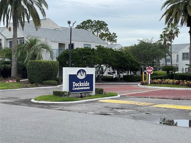 community / neighborhood sign featuring uncovered parking