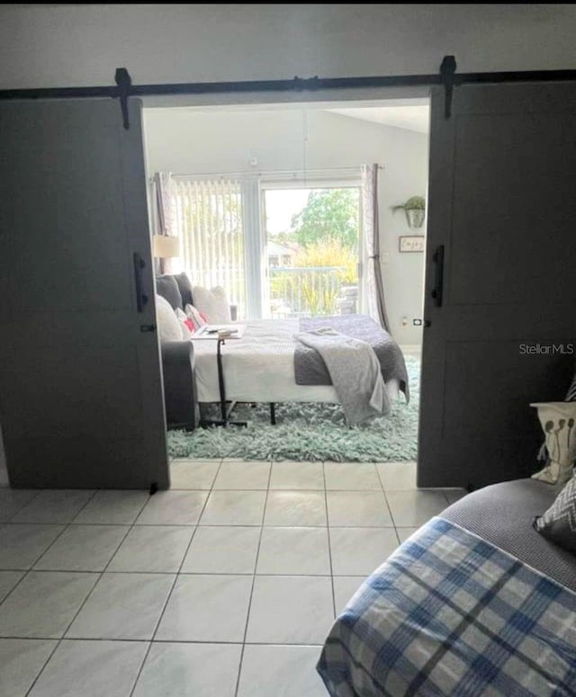 2560 Woodgate Blvd Unit 203, Orlando, FL 32822 - bedroom with a barn door and light tile patterned floors