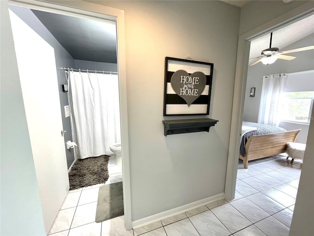 2560 Woodgate Blvd Unit 203, Orlando, FL 32822 - ensuite bathroom with a ceiling fan, toilet, baseboards, curtained shower, and tile patterned floors
