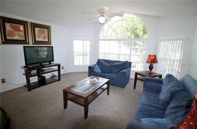 living area featuring ceiling fan, lofted ceiling, and carpet floors