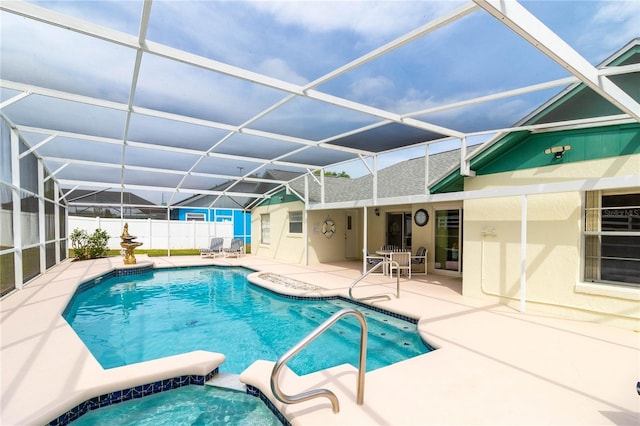view of swimming pool featuring a patio, fence, a lanai, and a pool with connected hot tub