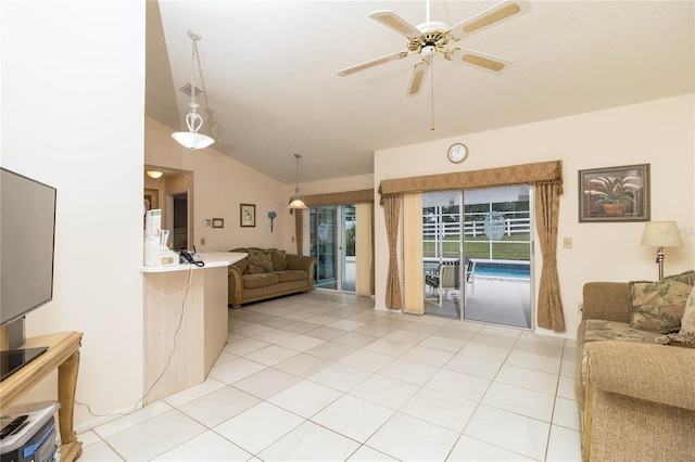 living room with light tile patterned floors, ceiling fan, and vaulted ceiling