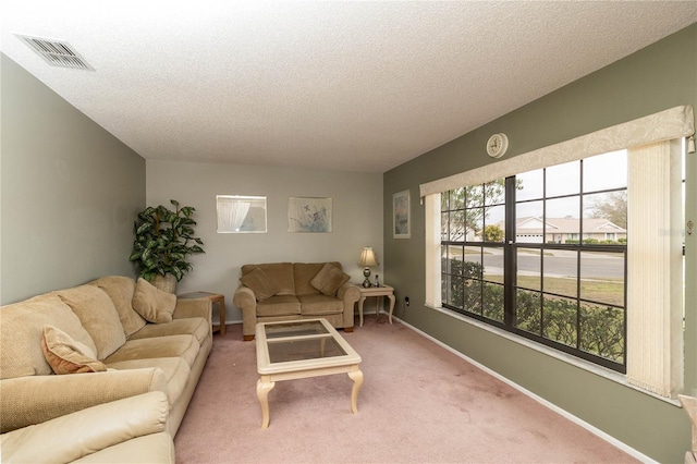 carpeted living room with baseboards, visible vents, and a textured ceiling