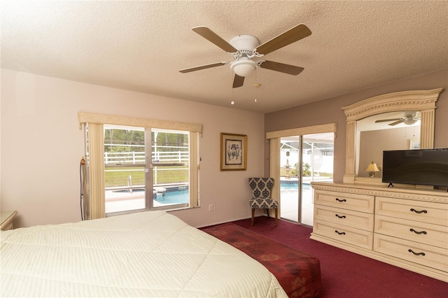 bedroom with dark carpet, access to outside, a textured ceiling, and multiple windows