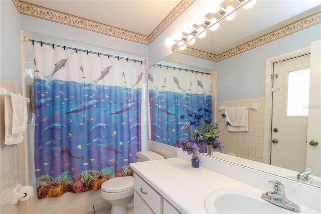 full bath with toilet, tile walls, shower / bath combo, and vanity