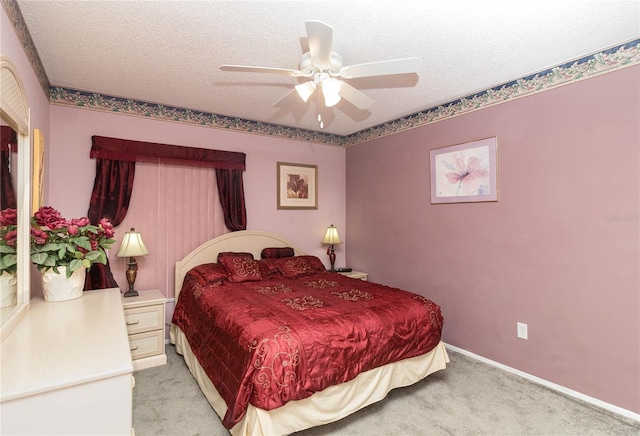 bedroom with a textured ceiling, ceiling fan, light colored carpet, and baseboards