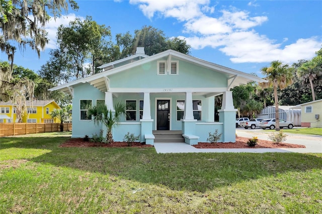 415 S 9th St, Leesburg, FL 34748 - view of front of house featuring a front lawn, stucco siding, covered porch, and fence