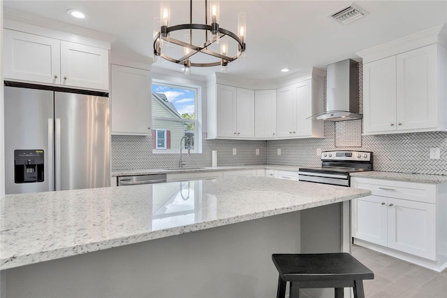 415 S 9th St, Leesburg, FL 34748 - kitchen featuring a sink, a chandelier, wall chimney exhaust hood, appliances with stainless steel finishes, and visible vents