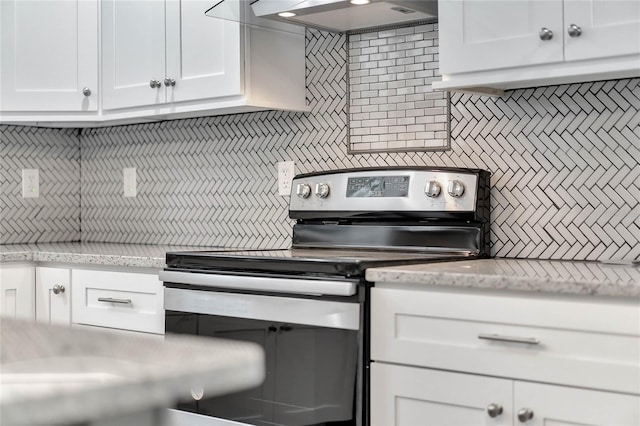 415 S 9th St, Leesburg, FL 34748 - kitchen featuring decorative backsplash, stainless steel range with electric stovetop, white cabinets, light stone countertops, and under cabinet range hood
